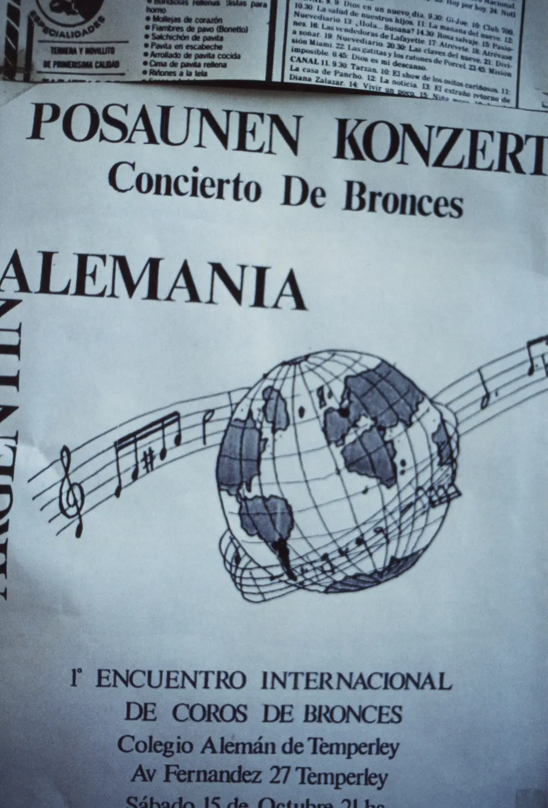 Afiche del Posaunen Konzert de 1988, con un globo terráqueo dibujado atravesado por un pentagrama con notas, fotografiado sobre una hoja de diario