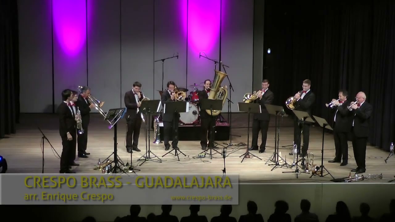 El Crespo Brass en escena, unos diez bronces tocando; al centro un trompetista de pelo oscuro junto a la tuba