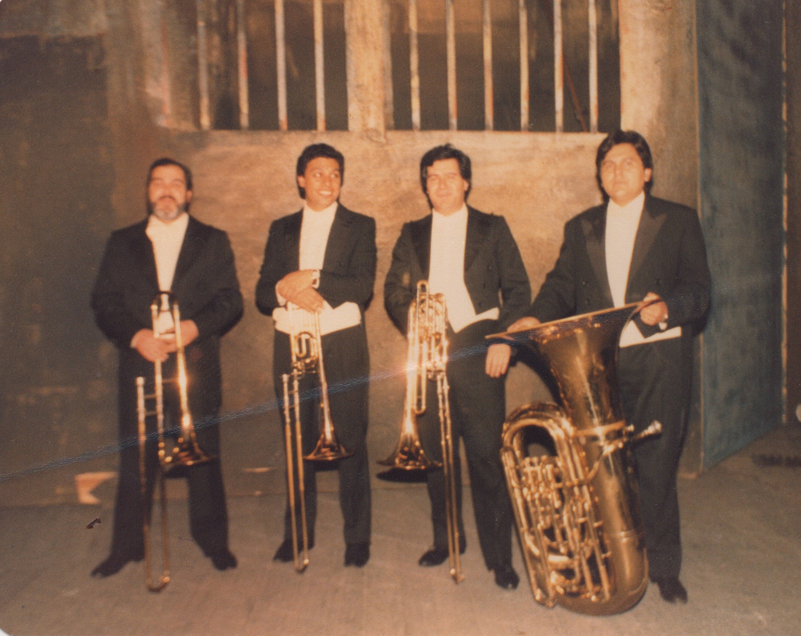 Cuatro músicos de gala posando con tres trombones y una tuba; Gaspar Licciardone está a la izquierda y Eduardo «Oso» López es el tercero desde la izquierda