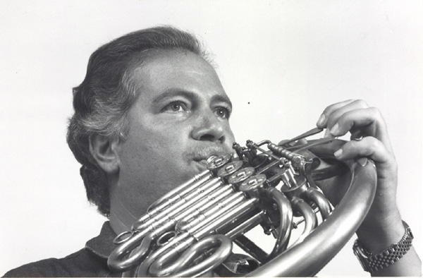Retrato de estudio en blanco y negro de Güelfo Nalli tocando el corno, la mirada levantada, pelo entrecano peinado hacia atrás