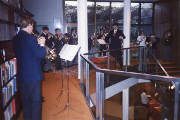 El coro tocando junto a una escalera y estanterías de libros en el interior de la Embajada Alemana, principios de los noventa