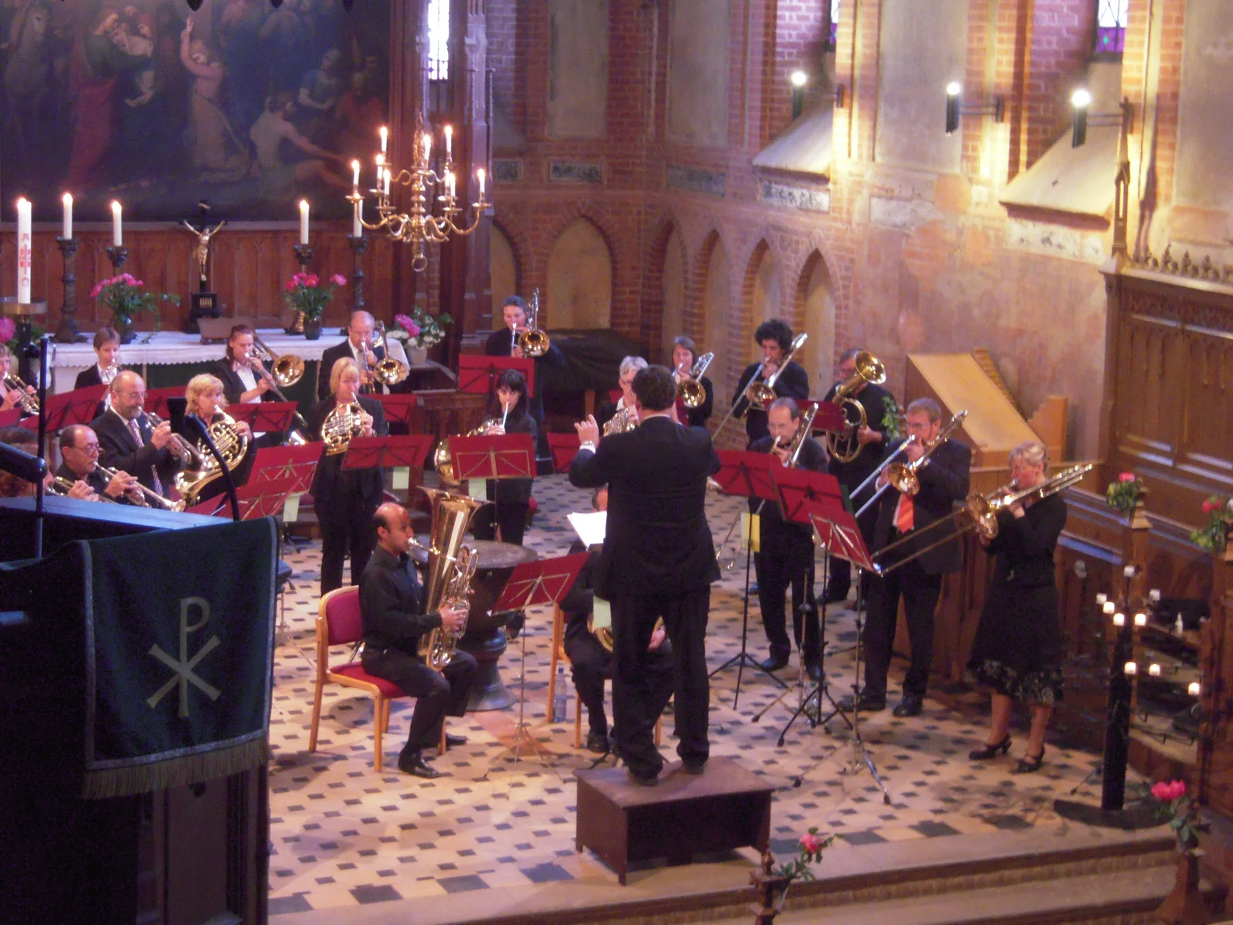 Los dos conjuntos tocando con atriles rojos dentro de la Stadtkirche St. Marien de Plau