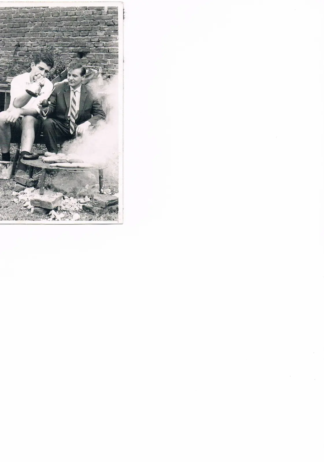 Johannes Maas y Gerhard Huss junto a una parrilla humeante en un patio de ladrillos, años sesenta