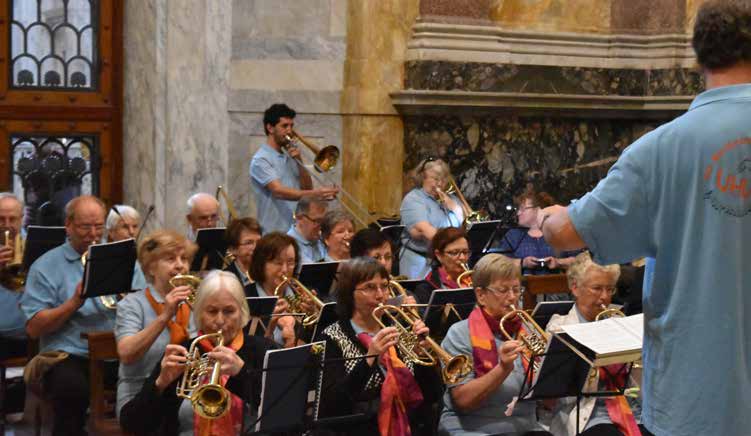 El conjunto tocando en la basílica visto desde el costado, con el director de espaldas en primer plano