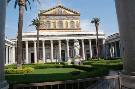 La fachada de mosaicos de San Pablo Extramuros vista desde el pórtico, con las palmeras del atrio