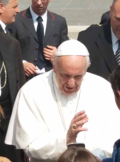 Primer plano del papa Francisco, de blanco, bendiciendo con la mano