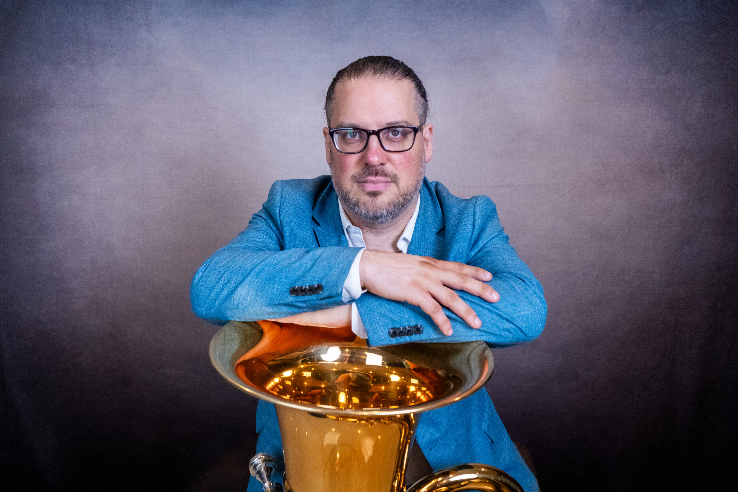 Porträt von Patricio Cosentino, die Arme auf dem Schallbecher der Tuba