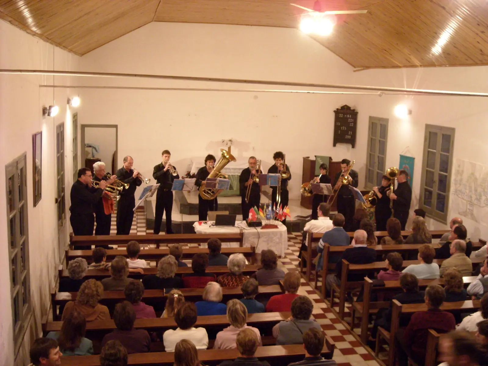 El conjunto de negro tocando frente al altar de una iglesia llena, vista desde el coro alto